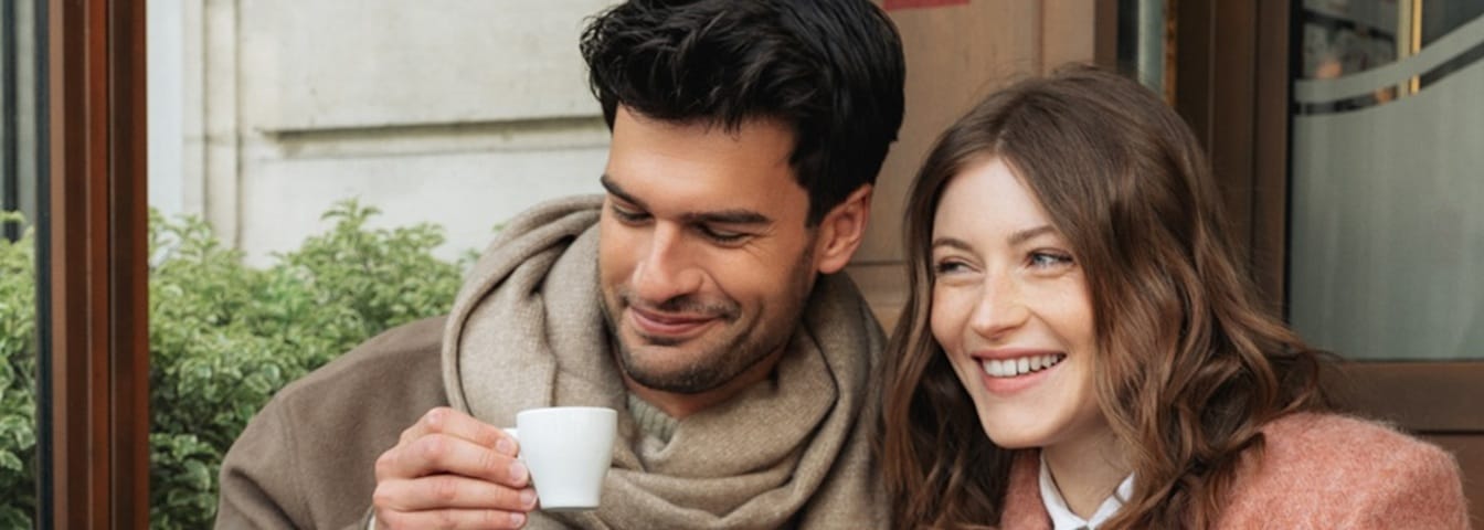 Couple buvant un café en terrasse pour la Saint-Valentin avec un bouquet de fleurs