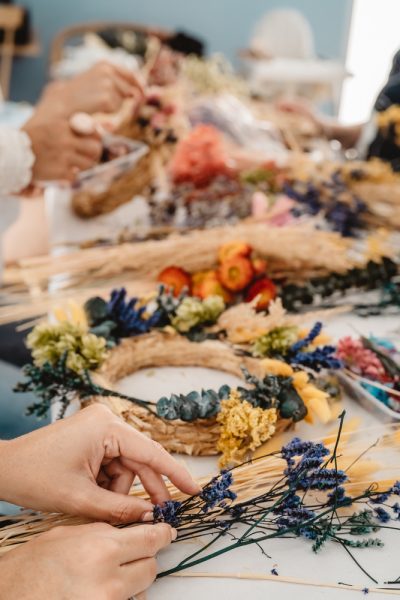 Personnes fabriquant des couronnes de fleurs séchées