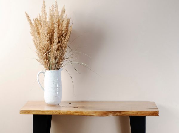 Table en bois avec un vase de fleurs séchées dessus