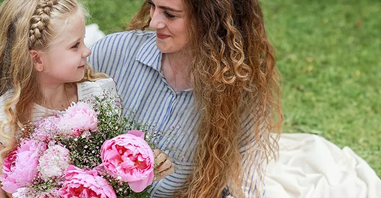 Maman avec sa fille avec un bouquet de fleurs