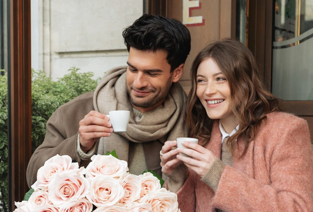 Couple buvant un café avec un bouquet de fleurs