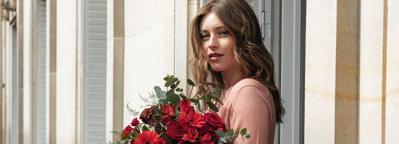 Femme tenant un bouquet de roses rouges