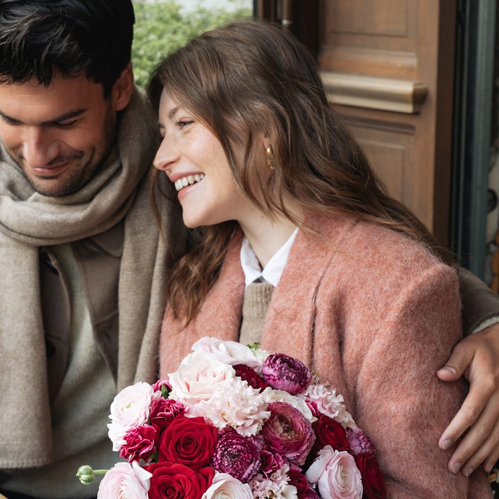Couple heureux en terrasse avec un bouquet de fleurs