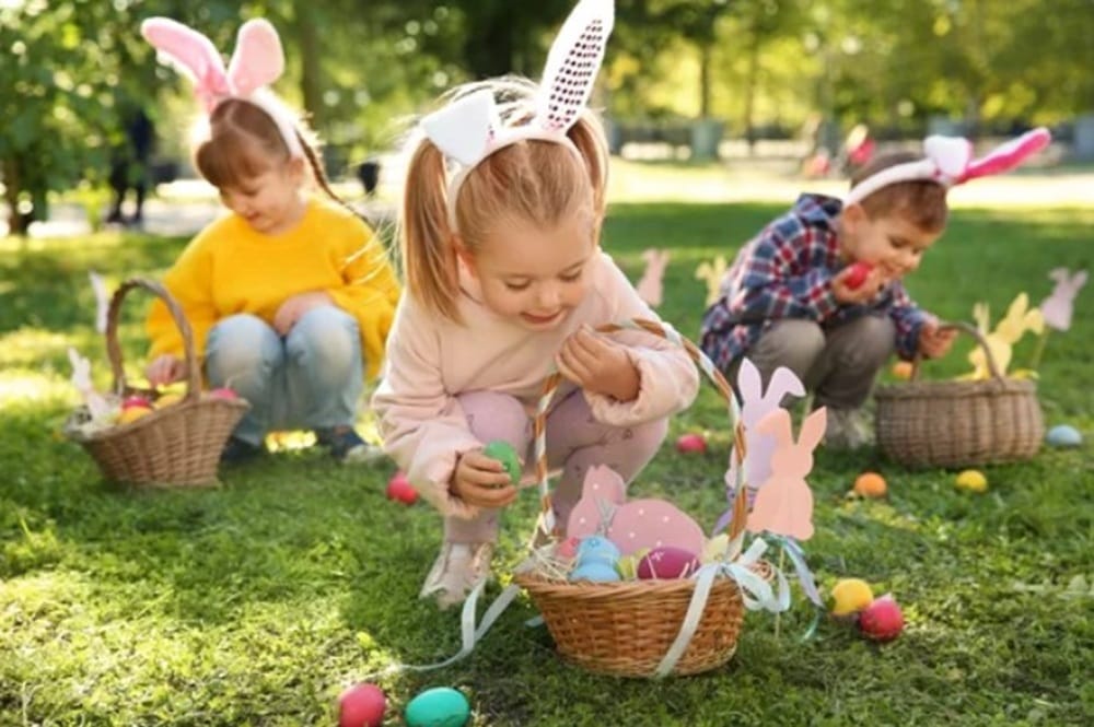 Enfants qui ramassent des oeufs en chocolat lors d'une chasse aux oeufs de pâques