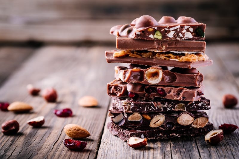 Carrés de chocolat empilés posés sur une table en bois