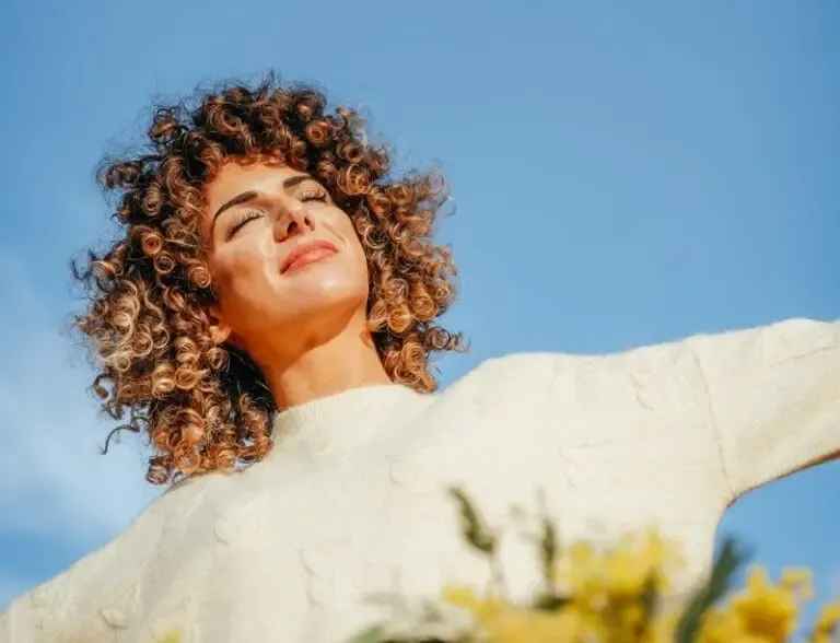 Femme souriant, yeux fermés, bras ouverts