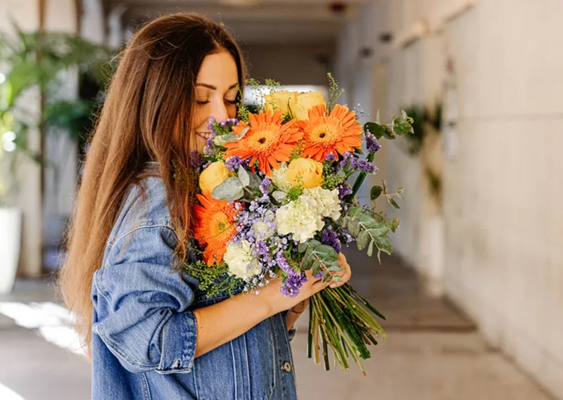 Femme sentant un bouquet de fleurs