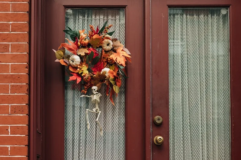 Couronne d'automne dans les tons orange accrochée à une porte