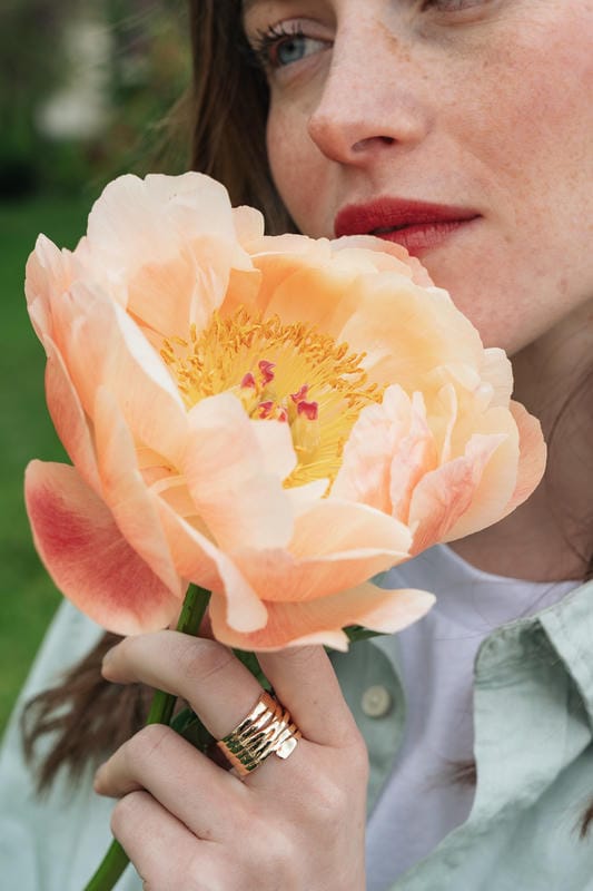 Femme tenant une pivoine saumon