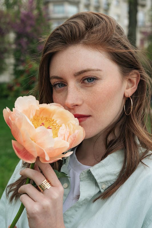 Femme tenant une pivoine couleur saumon