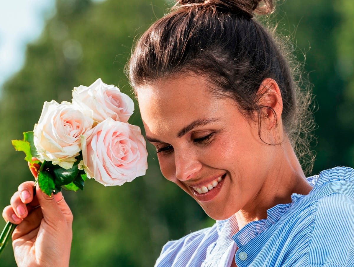 Femme tenant 3 roses roses