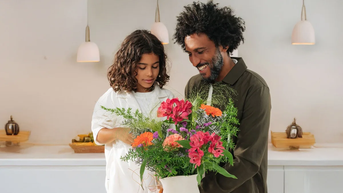 Un père et sa fille avec un bouquet de fleurs