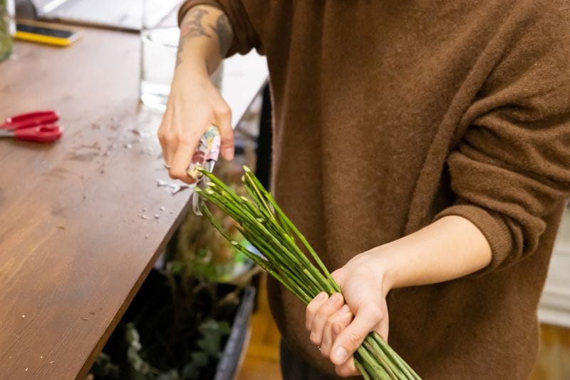 Fleuriste coupant les tiges d'un bouquet