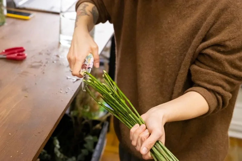 Fleuriste coupant les tiges d'un bouquet
