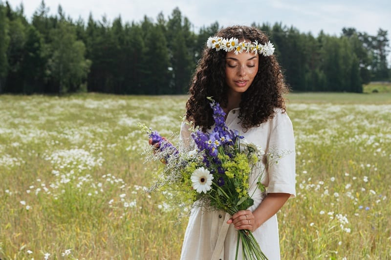 Femme tenant un bouquet de fleurs en extérieur