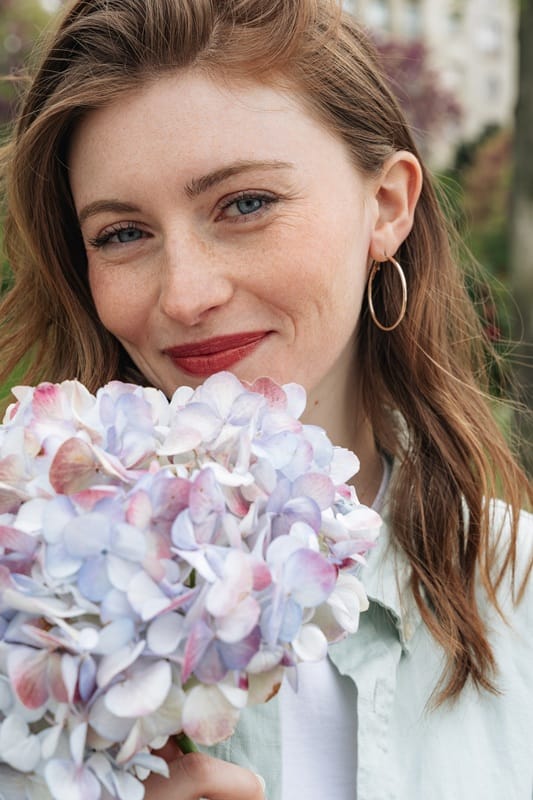 Femme tenant une fleur d'hortensia