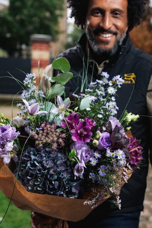 Livreur Interflora tenant un bouquet de fleurs