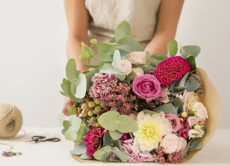 Une personne en train d'emballer un bouquet de fleurs