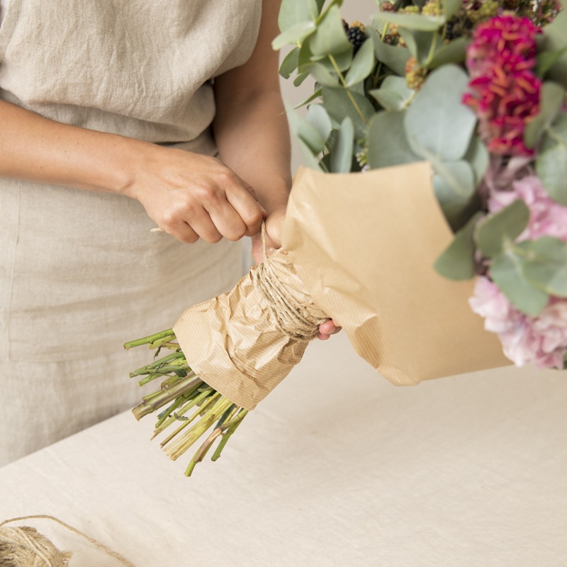 Une fleuriste emballant un bouquet de fleurs