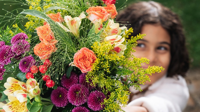 Petite-fille tendant un bouquet de fleurs