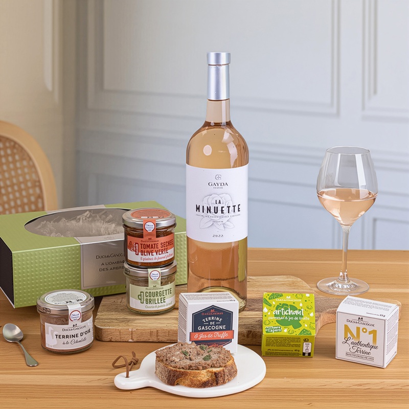 Bouteille de vin rosé et plusieurs bocaux de produits salés à déguster présentés sur une table