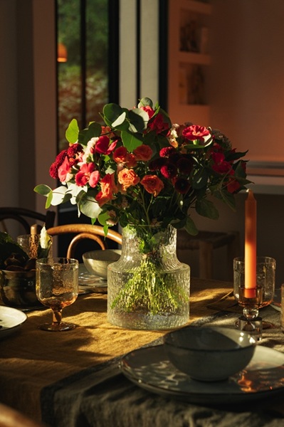 Bouquet de fleurs automnales sur une table, éclairé d'une lumière chaleureuse