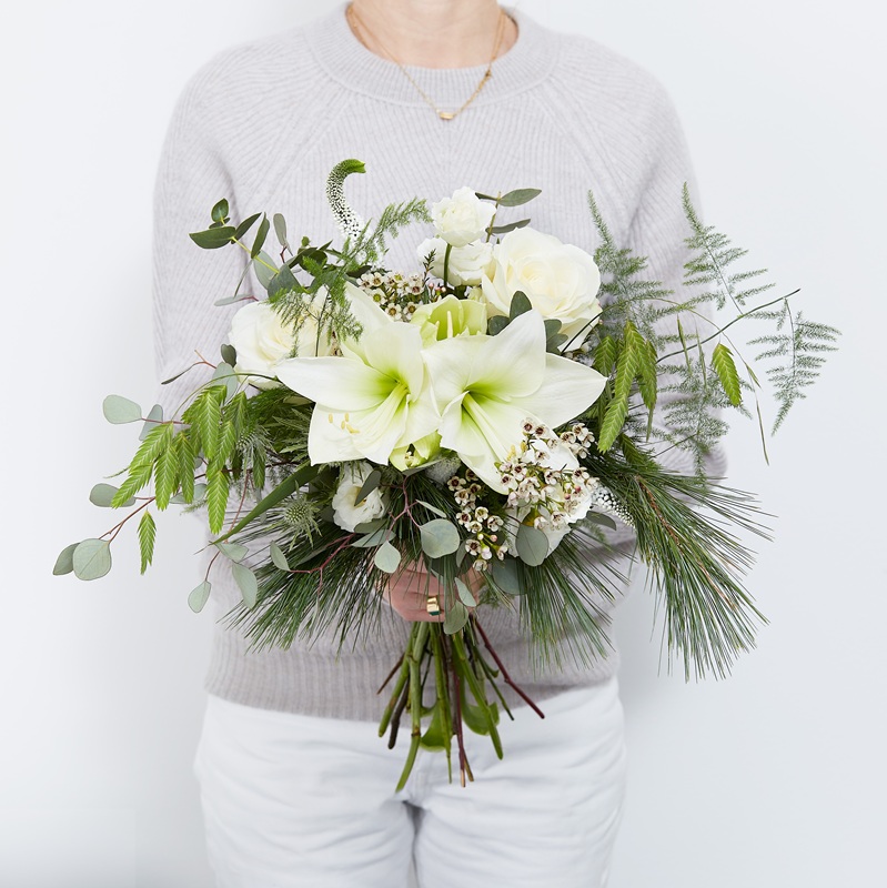 Femme tenant un bouquet d'amaryllis blanches