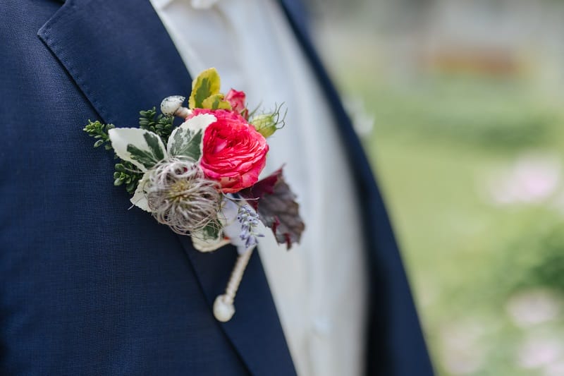 Une boutonnière de mariage attachée sur le revers d'un costume