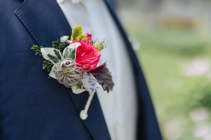 Une boutonnière de mariage attachée sur le revers d'un costume