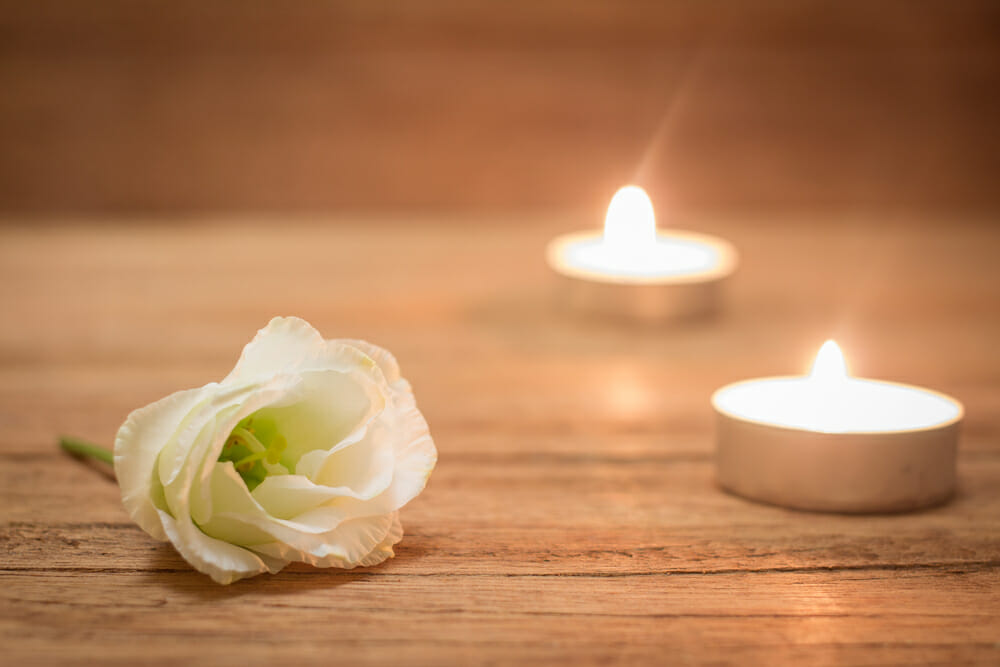 Une rose blanche et des bougies allumées