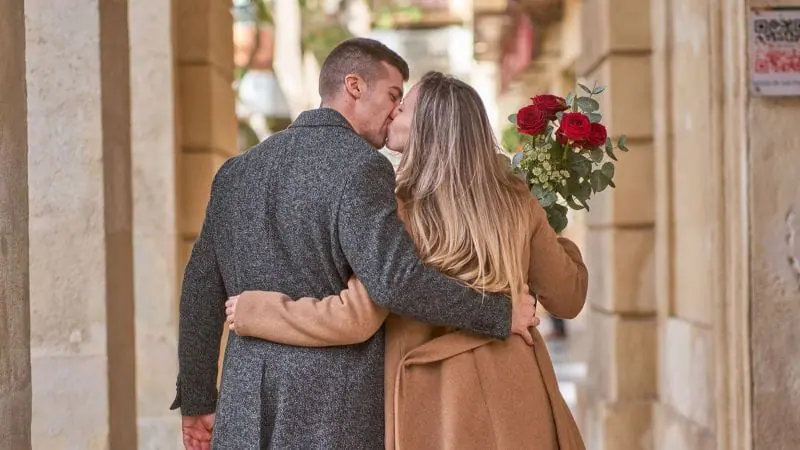 Couple qui s'embrassent et se font un bisou dans la rue 