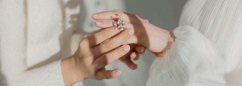 Deux mains qui se tient avec une petite fleur 