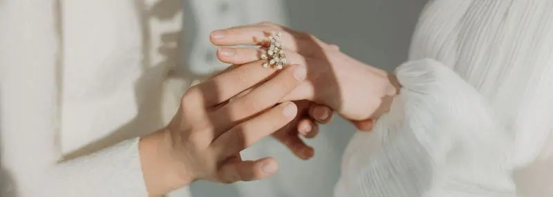 Deux mains qui se tient avec une petite fleur 