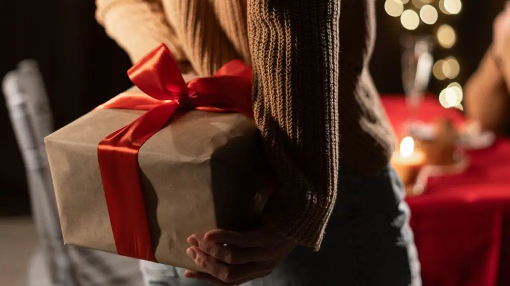 Femme avec un cadeau dans ces mains 