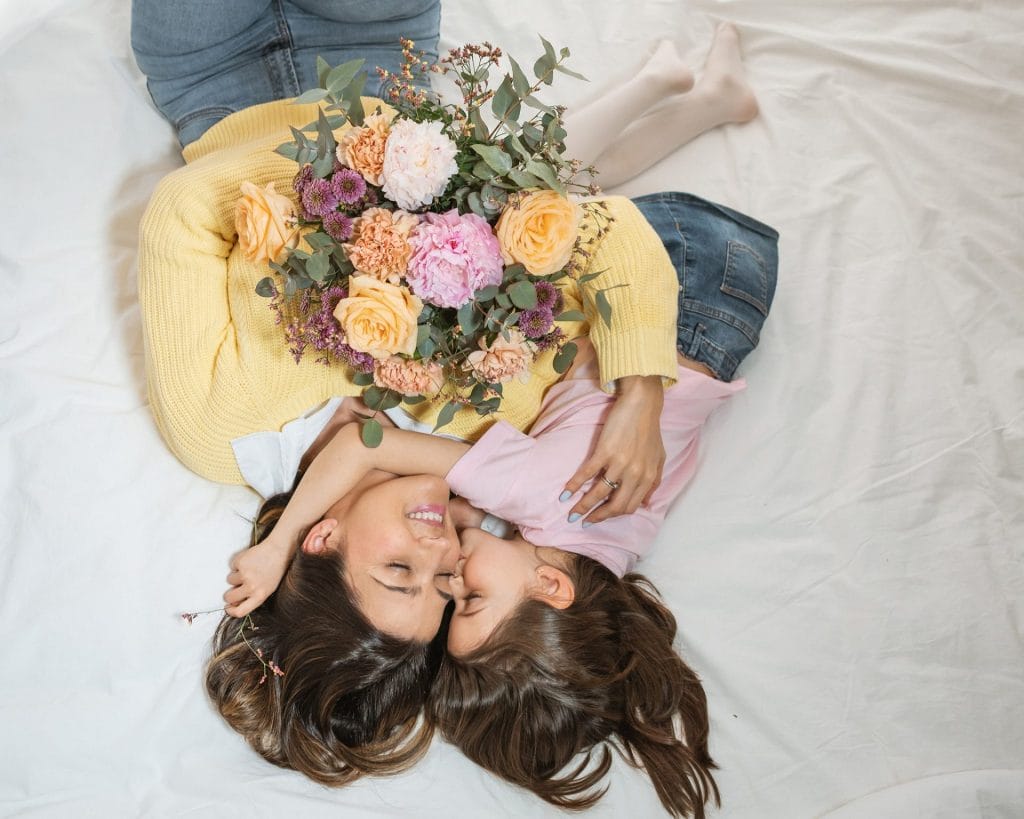 mère et fille allongées avec un bouquet de fleurs