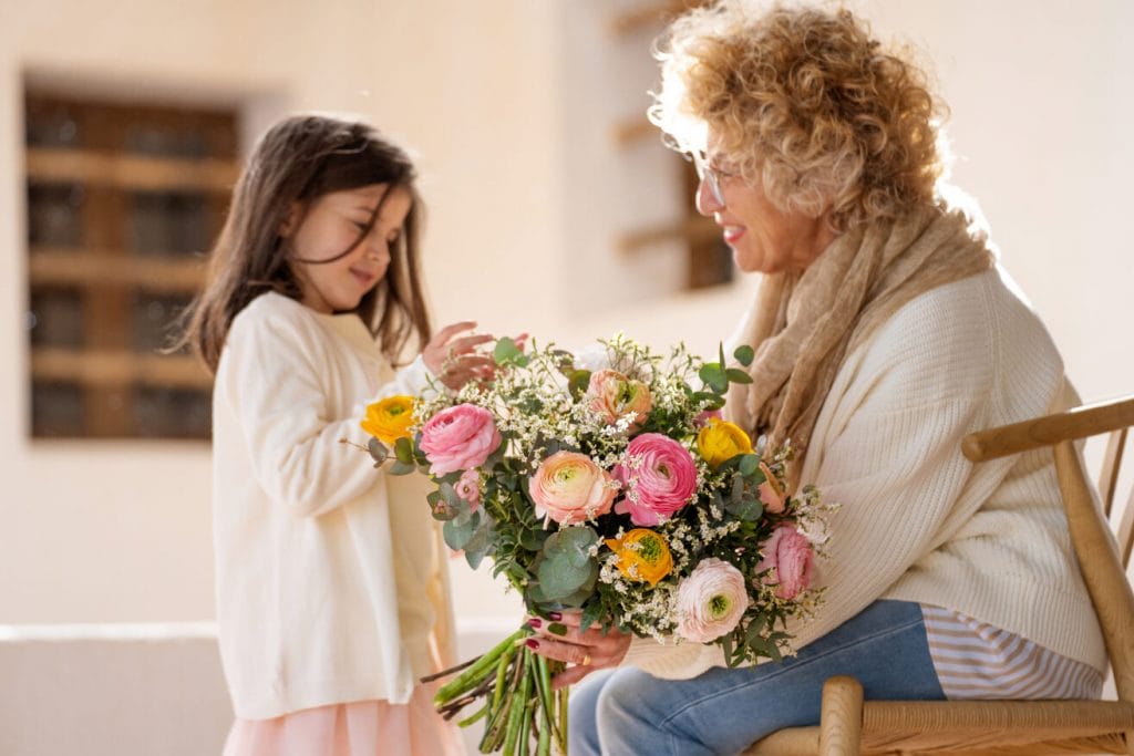 Grand mère avec sa petite fille et un bouquet de roses