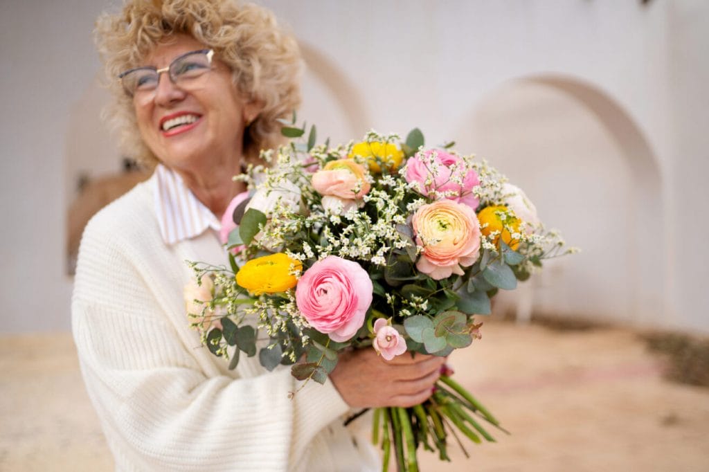 Grand-mère heureuse avec un bouquet de fleurs colorés
