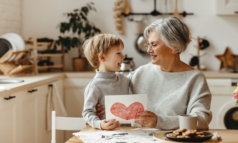 Une grand-mère découvre une carte faite par son petit-fils en le tenant contre elle