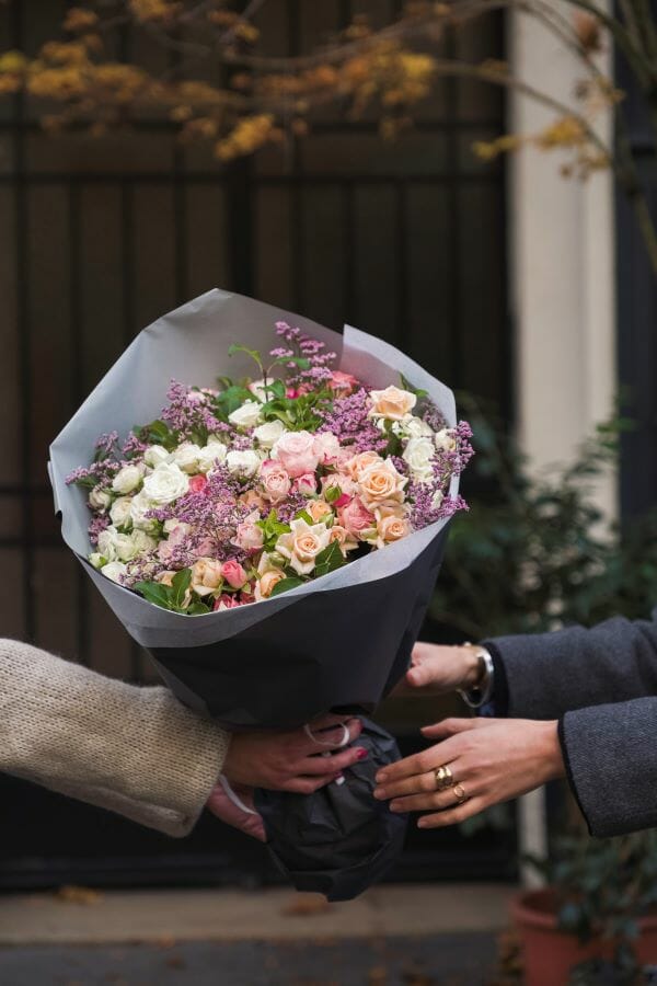 Livraison d'un bouquet de fleurs par un fleuriste ouvert