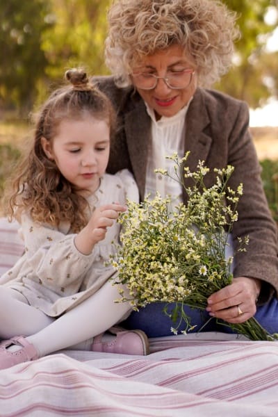 une petite-fille et sa mamie avec un bouquet de marguerites