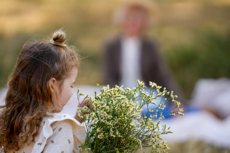 Une petite fille va offrir un bouquet de marguerites à sa mamie