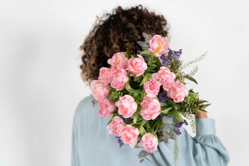 Une femme tenant un bouquet sur son épaule