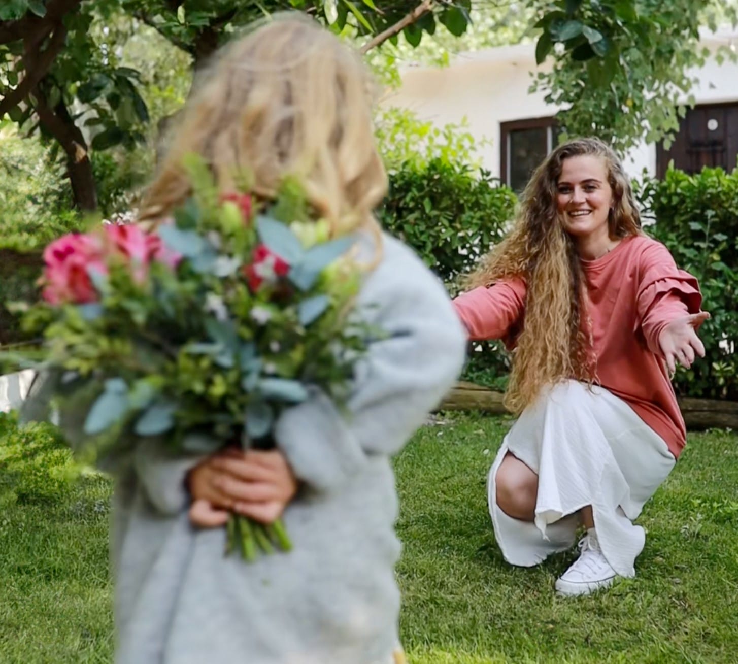 fille qui offre bouquet de fleur à sa mère