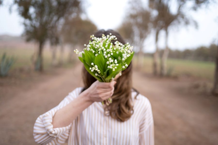 Une femme avec un bouquet de muguet