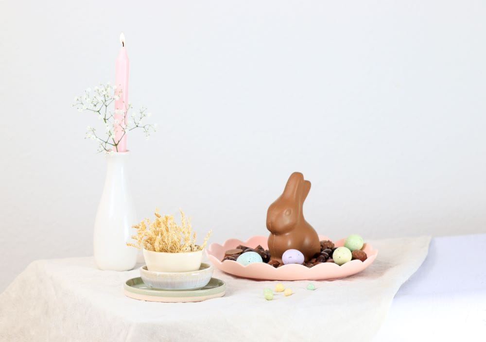 table avec lapin de chocolat et bougie pâque