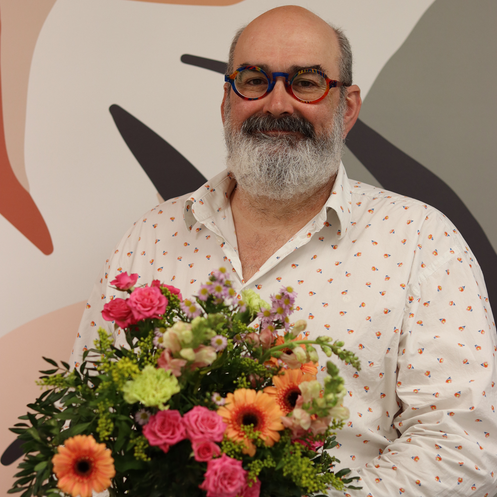 Claude Picgirard, artisan fleuriste du réseau Interflora, présentant un bouquet coloré