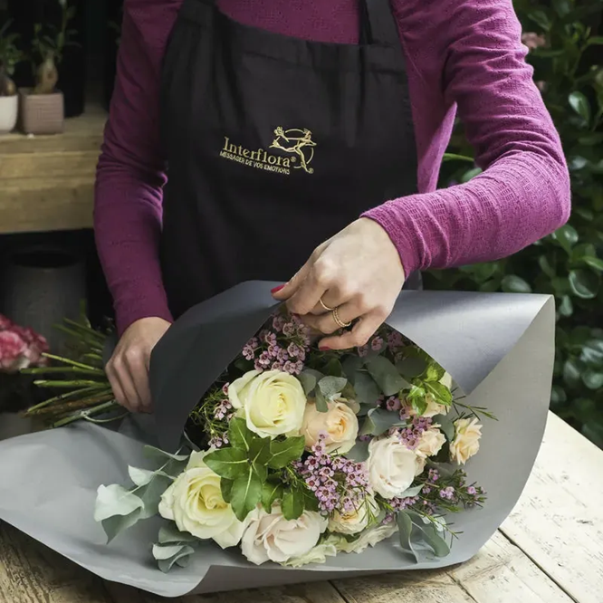 Fleuriste Interflora confectionnant un bouquet de roses blanches avant livraison